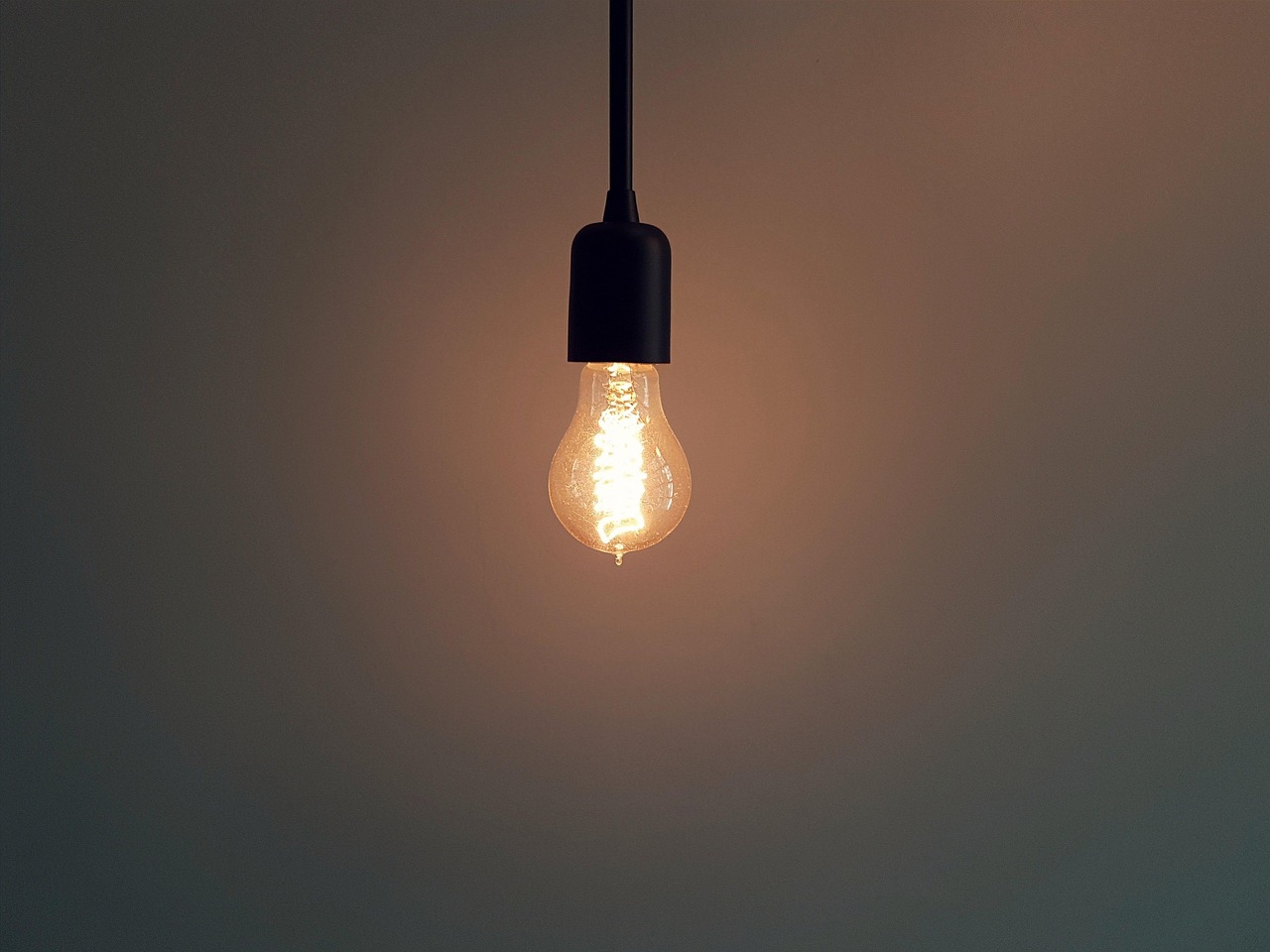 Strakke zwarte hanglampen in industriële keuken.