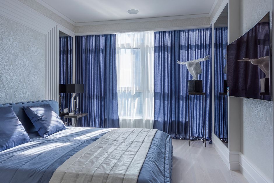Slaapkamer met stijlvolle blauwe gordijnen.
